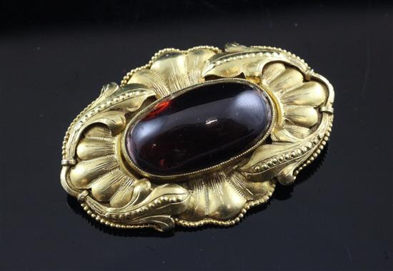 A late 19th/early 20th century continental gold and oval cabochon garnet set brooch(-)